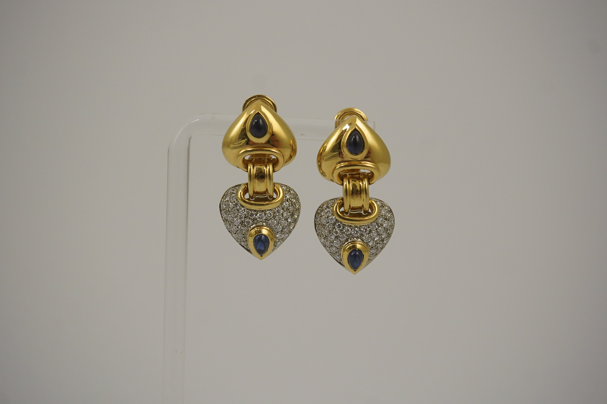 A modern pair of Mappin & Webb 18ct gold, cabochon sapphire and diamond cluster set stylised heart shaped drop earrings